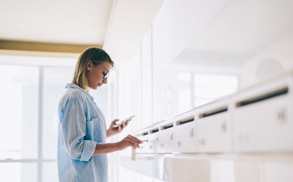 chica cogiendo cartas de un buzón