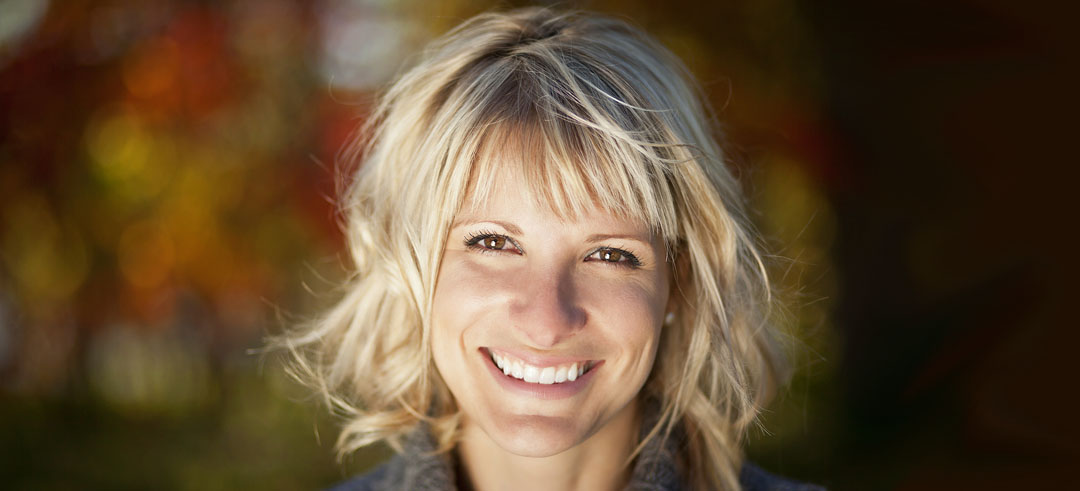 Mujer joven rubia con el pelo por los hombros sonriente mirando a la cámara