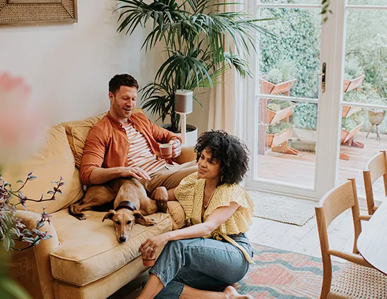 Dos personas y un perro hablando en el salón