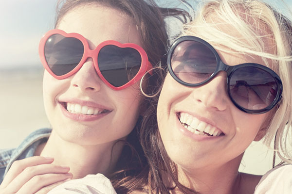 dos jóvenes sonrientes con gafas de sol